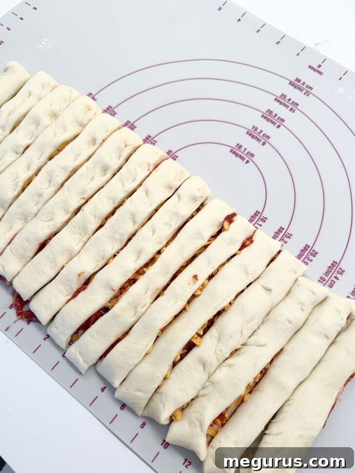 Dough rectangle sliced into even, 1-inch wide strips.