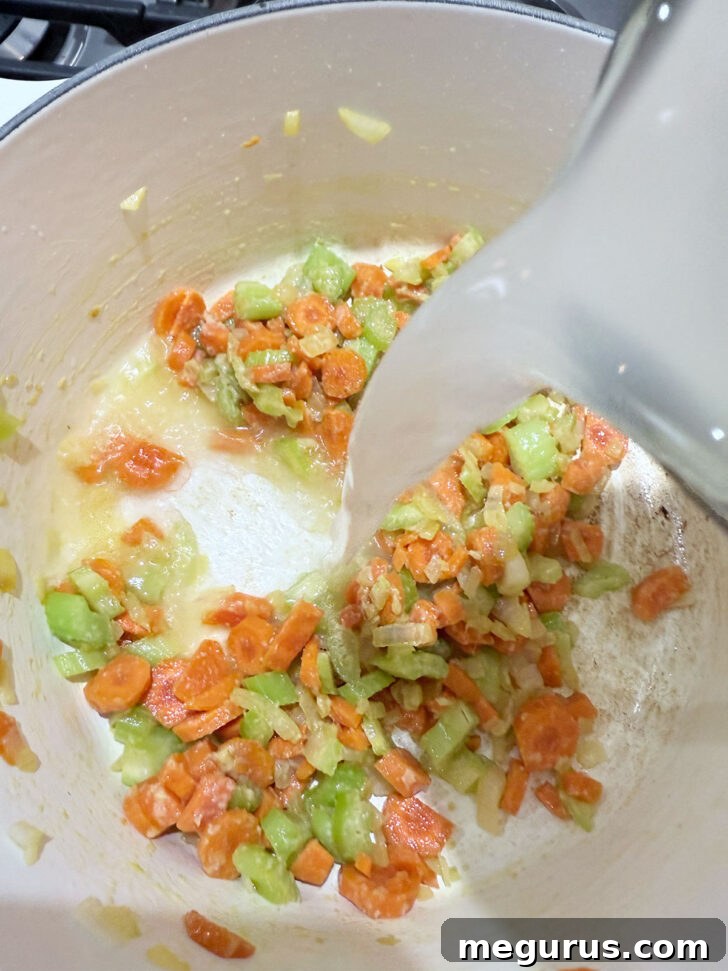 Adding broth to the cooked vegetables