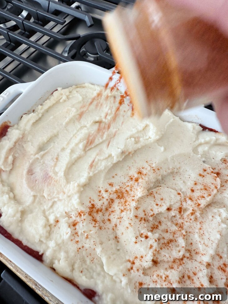 Sprinkling paprika on the mashed potatoes for color and flavor.