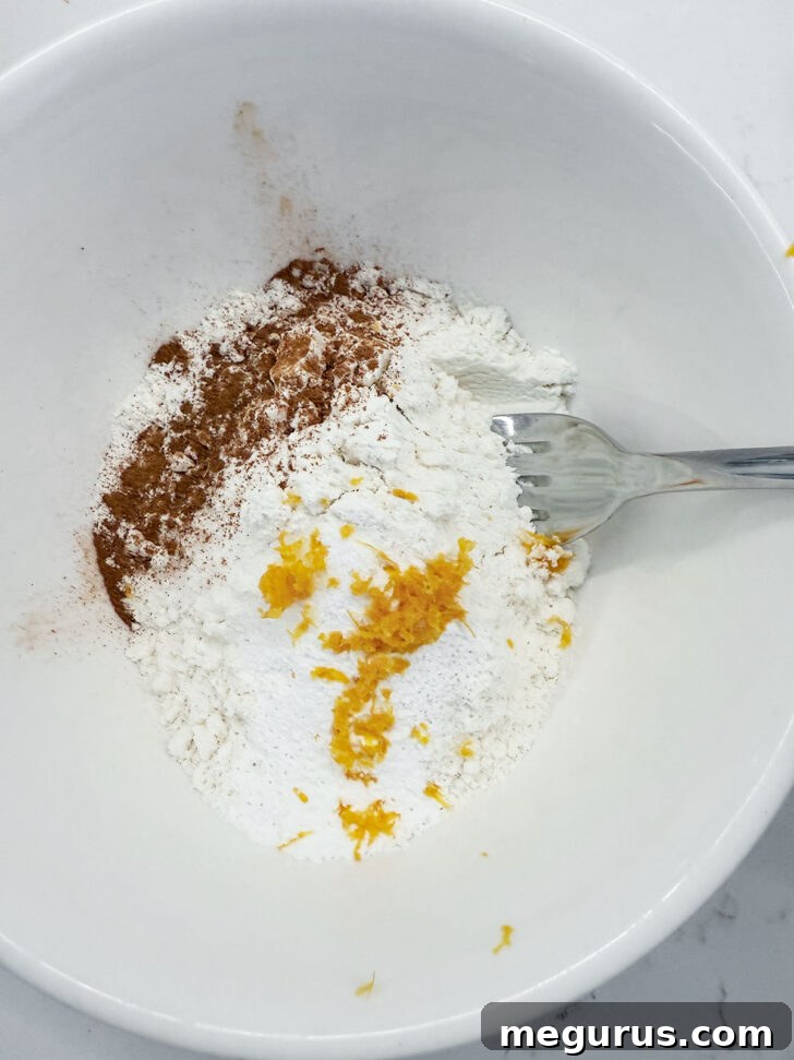 Dry ingredients like flour, baking powder, salt, and cinnamon in a separate bowl.