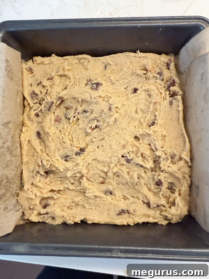 Batter evenly spread into a parchment-lined 8x8 inch baking pan.