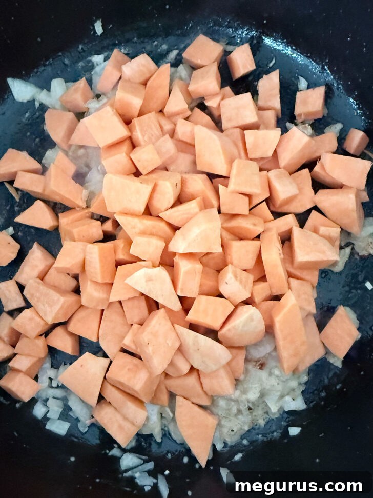 Adding the diced sweet potato to the skillet.