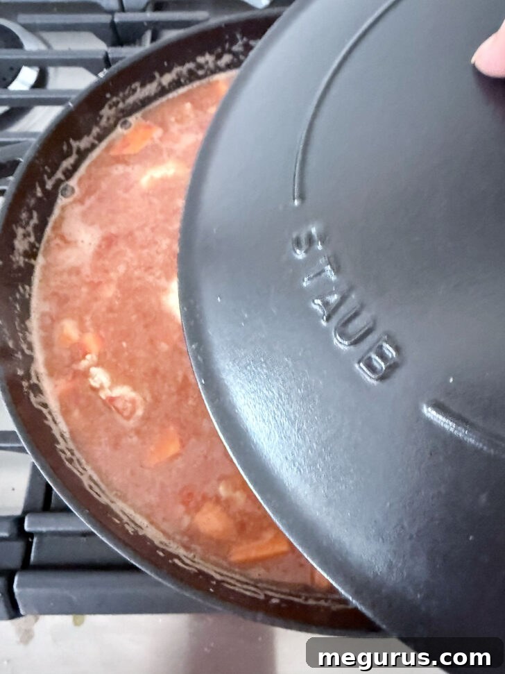 Placing a lid on top of the skillet.