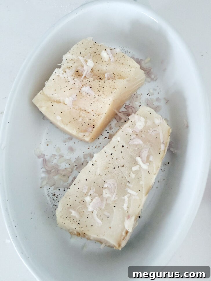Finely diced shallots scattered evenly over the halibut fillets.