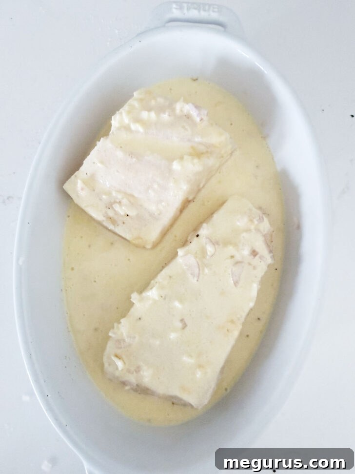 Baking dish with creamy lemon halibut, ready to be placed in the oven.