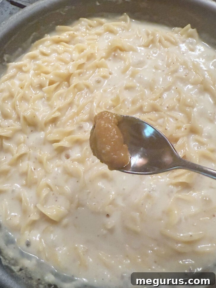 Adding a bit more chicken bouillon to the noodles.