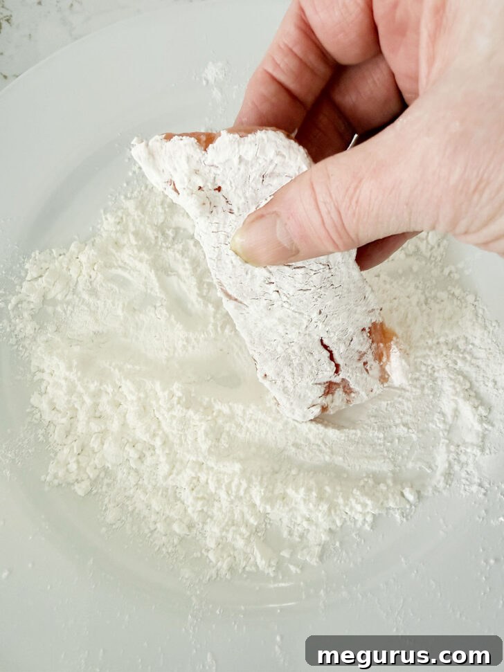 Dredging the salmon pieces in cornstarch.