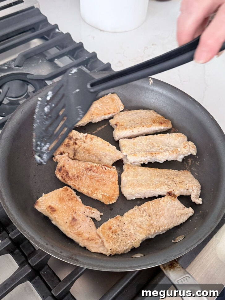 Pan frying the salmon until golden and crispy.