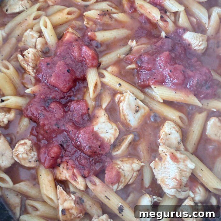 More tomatoes added to the skillet, enriching the sauce.