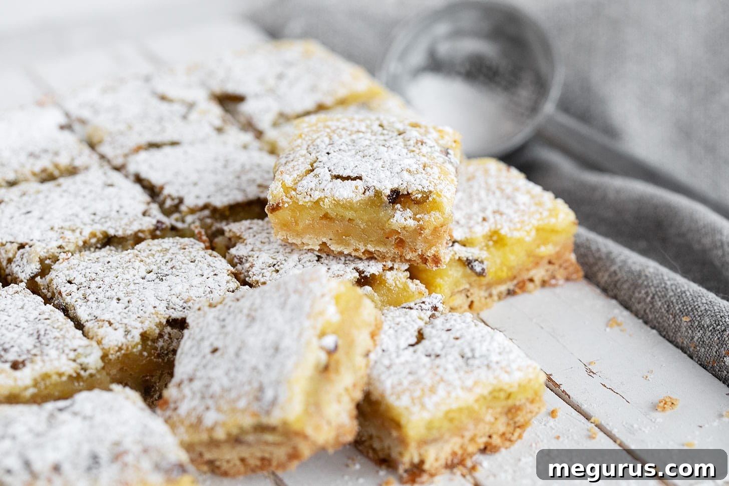Lemon pistachio shortbread squares cut on a serving board.