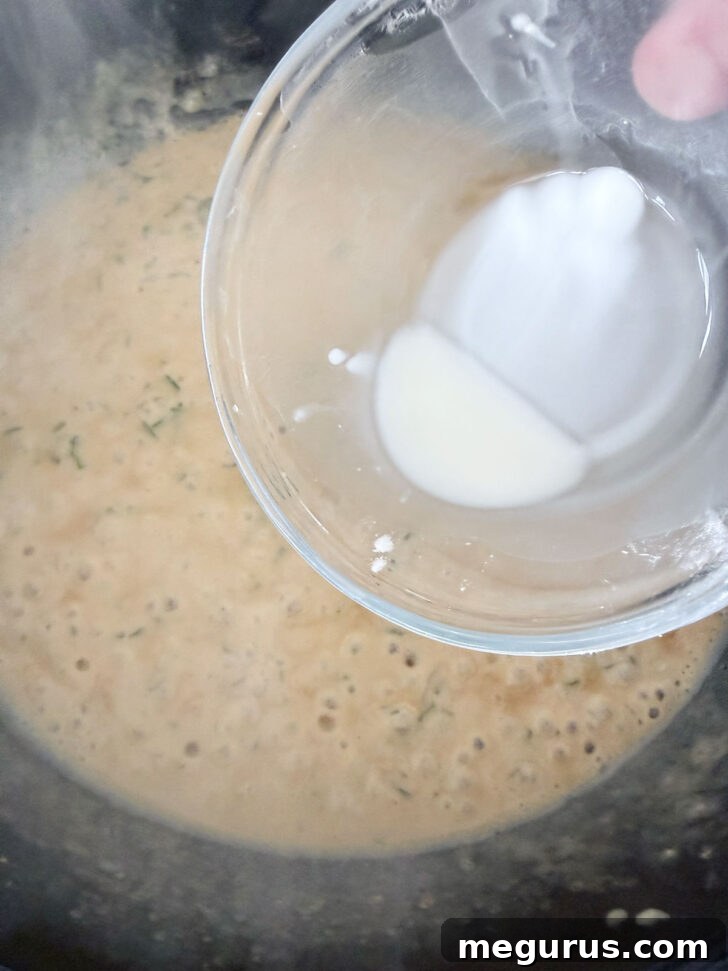 A cornstarch slurry being drizzled into the simmering sauce to thicken it, with fresh parsley added.