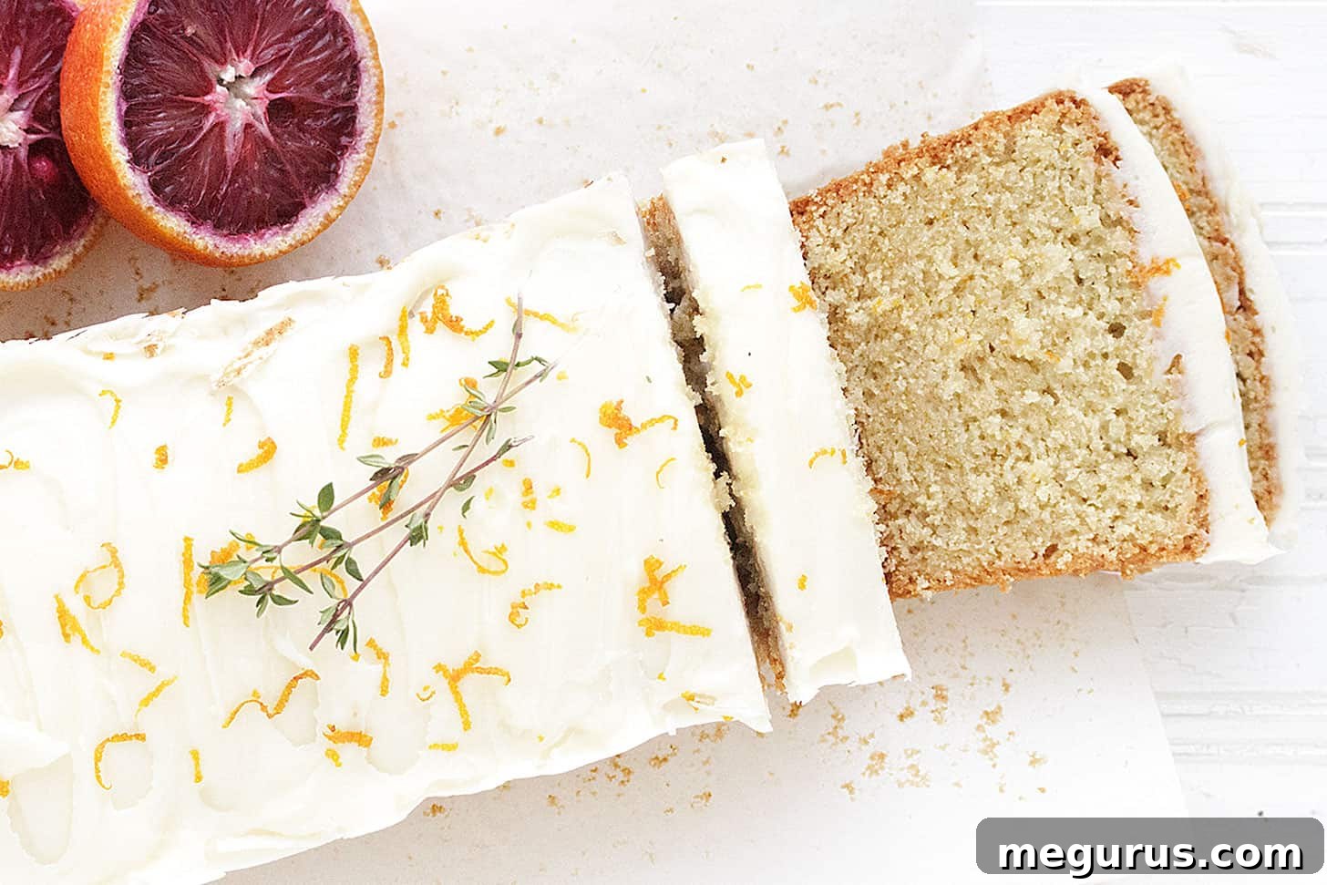 Delicious whole orange loaf cake sliced and ready to serve, showing its moist texture.