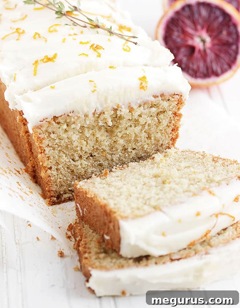 Close-up of a whole orange tea cake, showcasing its delicate crumb and vibrant orange color.