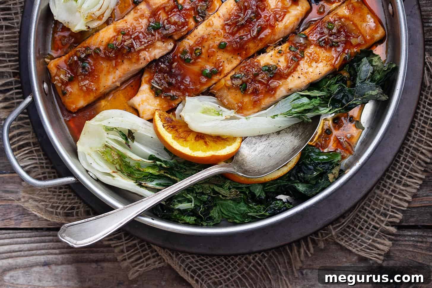 spicy orange salmon in baking dish with bok choy
