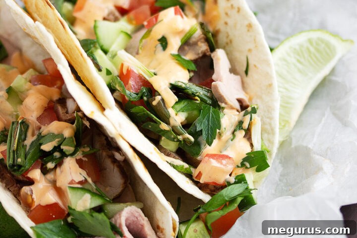 Asian inspired pork tacos on parchment paper, presented beautifully for the recipe card.