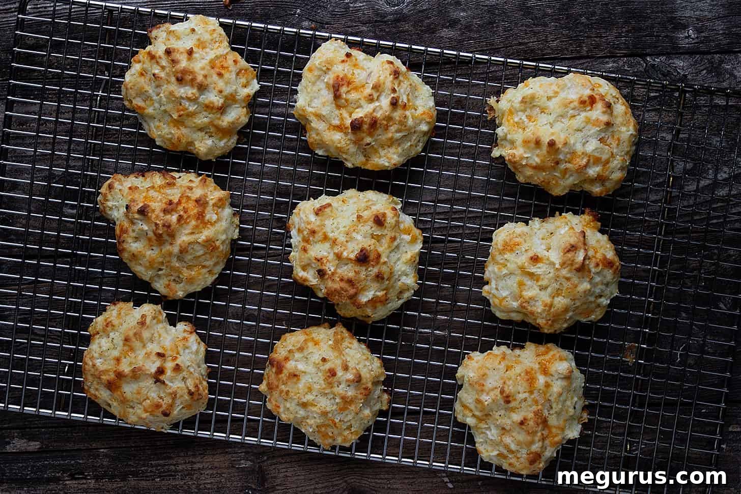 Golden-brown cheddar apple biscuits cooling on a rack, ready to be enjoyed.