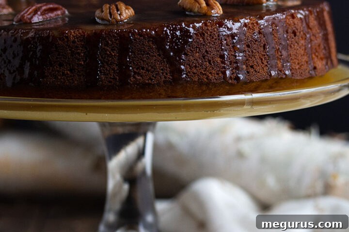 Close-up of a golden-brown Pecan Banana Toffee Cake on a festive serving plate.