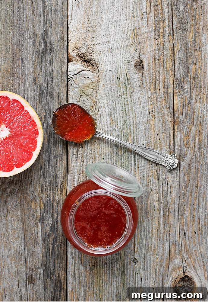 Freshly prepared small-batch grapefruit jam in three elegant glass jars, ready for enjoyment.