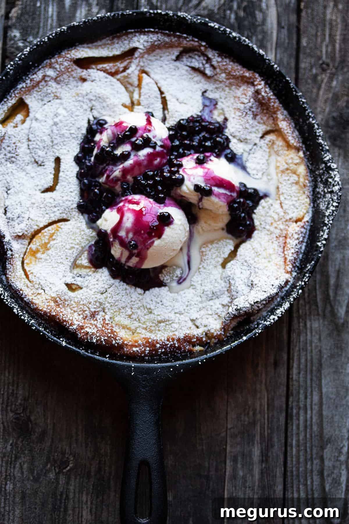 peach Dutch baby with blueberry sauce in cast iron skillet