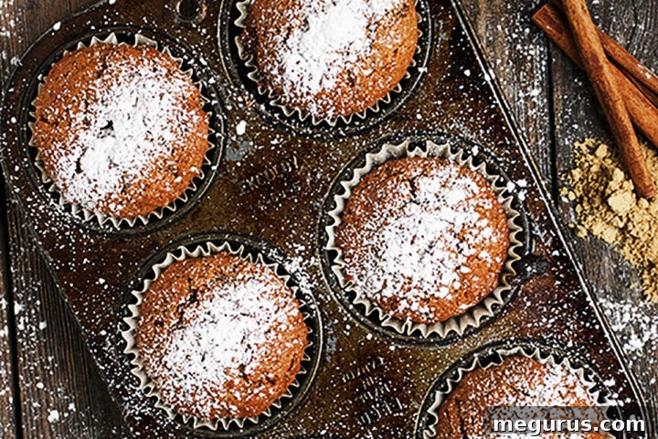 gingerbread muffins on muffin tin with powdered sugar