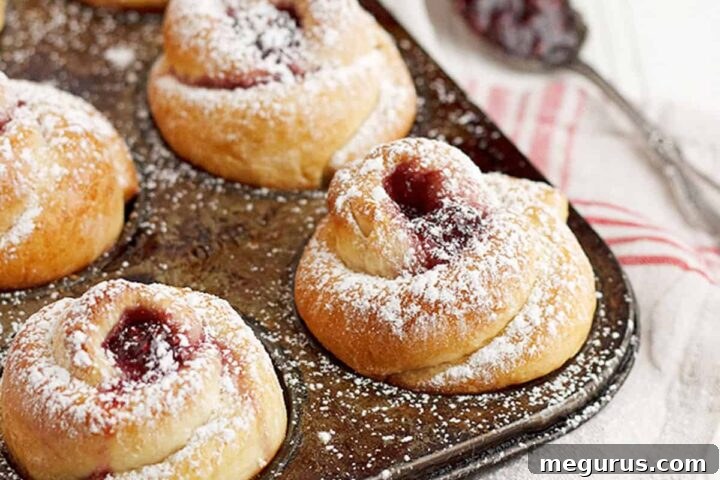 Rose shaped buns in muffin tin with raspberry jam