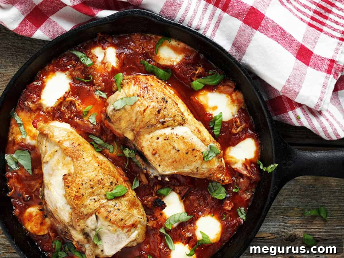 Crispy-skinned chicken bocconcini in a skillet with melted cheese and fresh basil