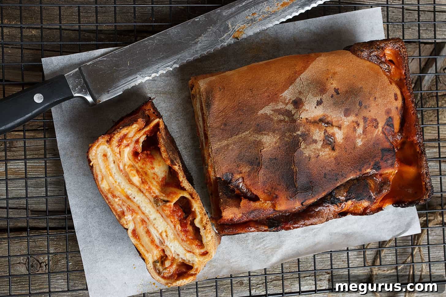 Sliced Italian Scaccia Ragusana revealing savory layers on parchment paper