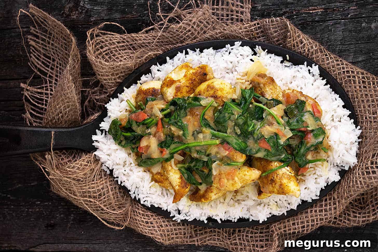 Brazilian chicken curry with spinach in skillet with rice