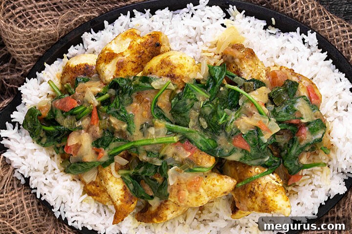 Brazilian chicken curry with spinach in skillet with rice