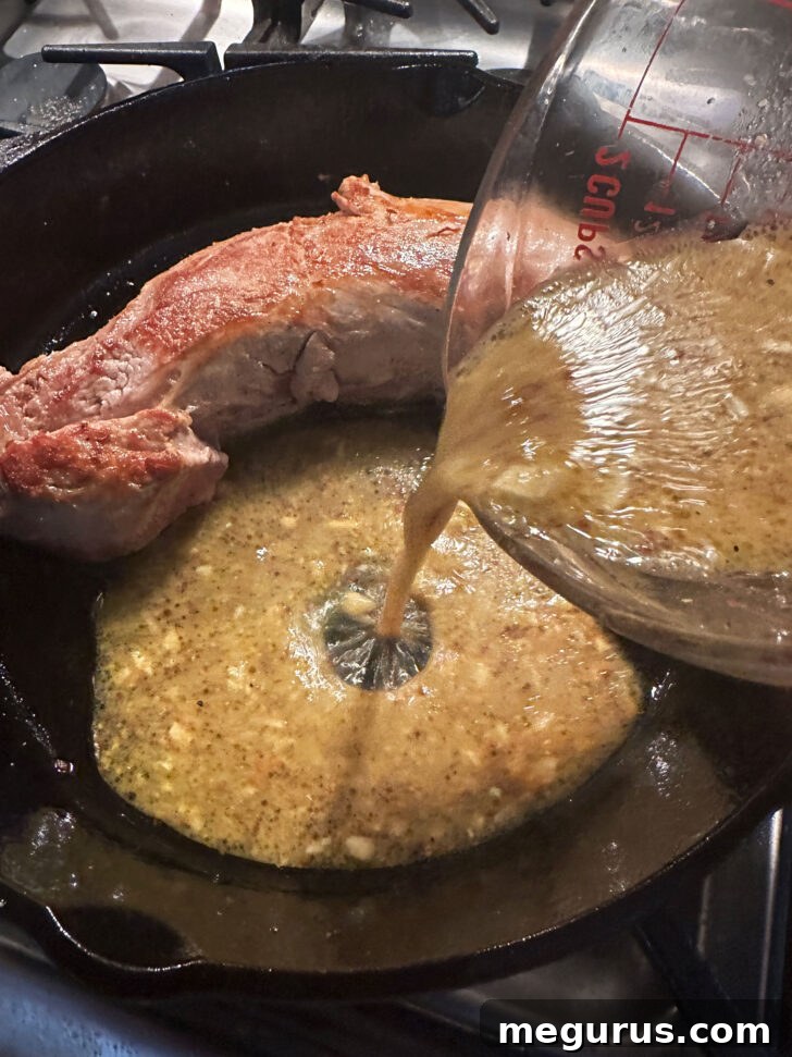 Pouring the prepared maple mustard sauce directly into the skillet over the seared pork