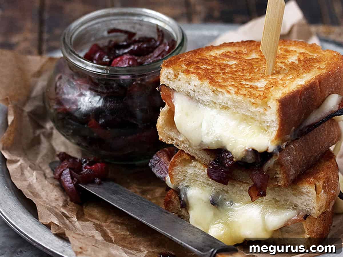 Gourmet cheese curd grilled cheese with bacon onion marmalade on a plate, ready to be enjoyed.