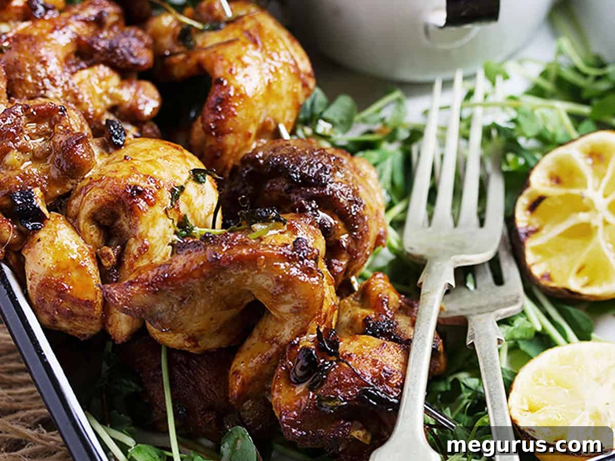 Portuguese chicken skewers on platter with lemons