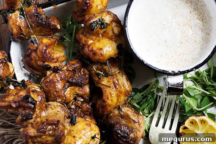 Portuguese chicken skewers on platter with lemons