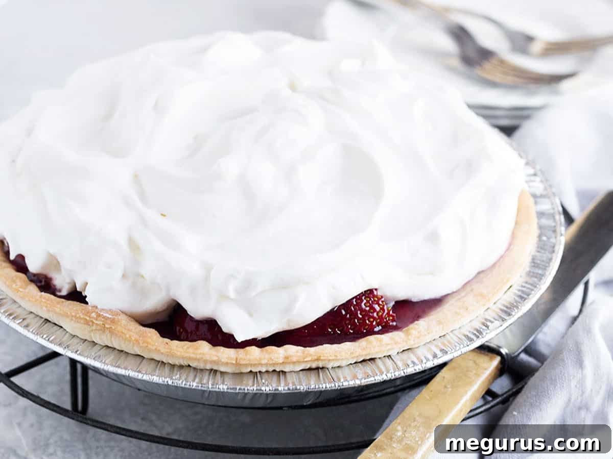 Fresh Strawberry Glaze Pie on a cooling rack with a serving knife