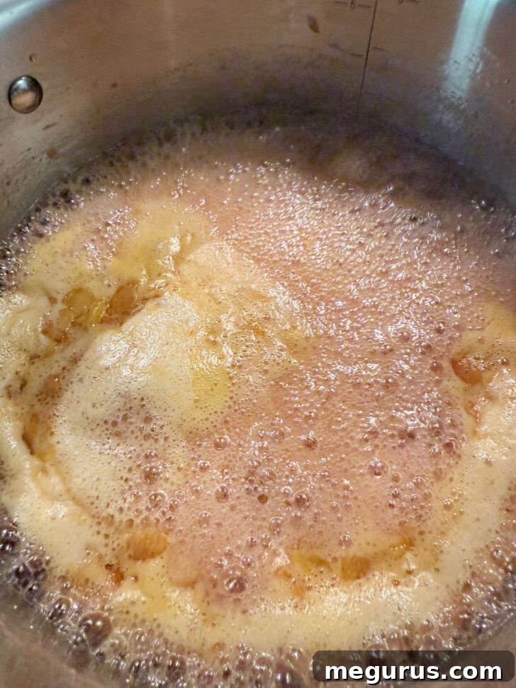 The peach and pepper jam mixture at a full, rolling boil.