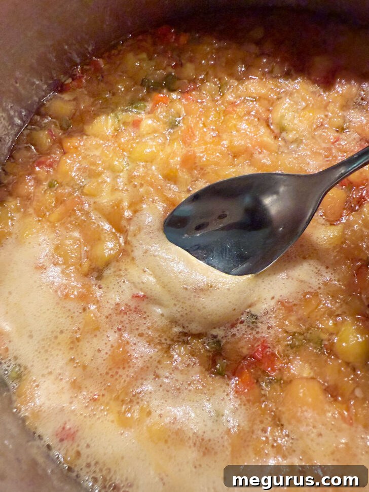 Skimming off the excess foam from the surface of the cooked jam.