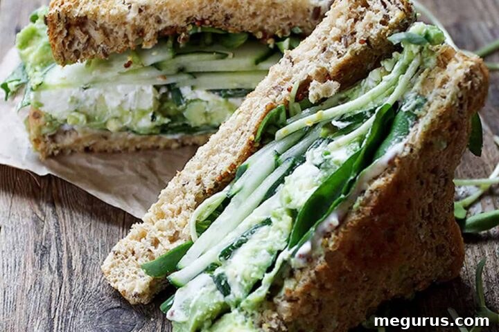 Close-up of a vibrant Green Goodness Sandwich cut in half, showcasing layers