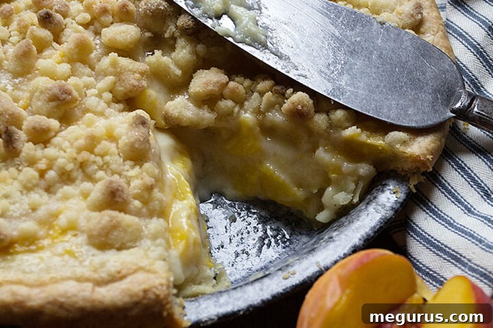 peaches and cream pie in pie pan with slice out