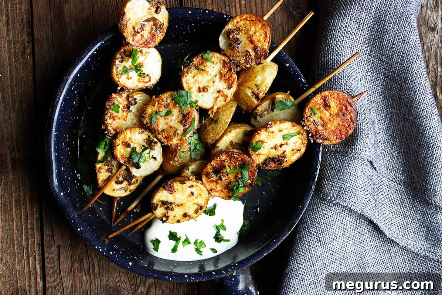 herb and garlic potato skewers in skillet with sour cream