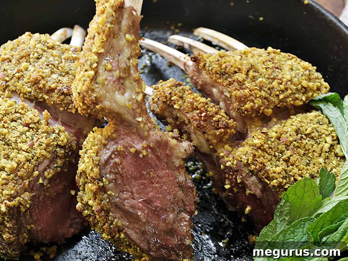 Perfectly seared almond crusted lamb chops in a cast iron skillet, ready to serve.