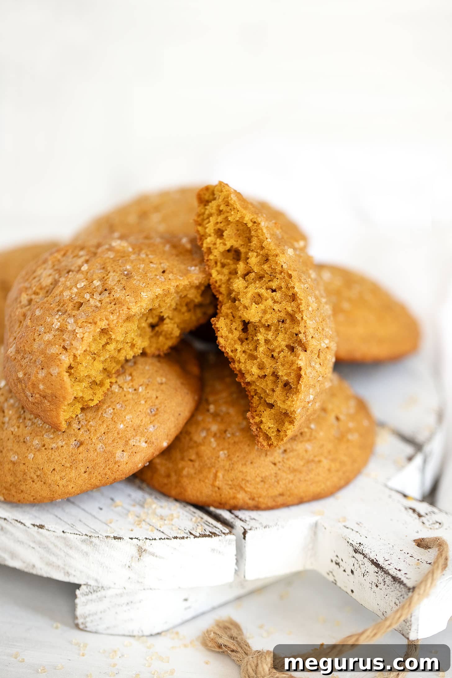 soft pumpkin cookies stacked on a serving board with fall decor