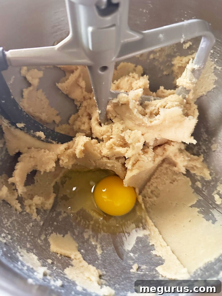adding egg to cookie dough in mixer