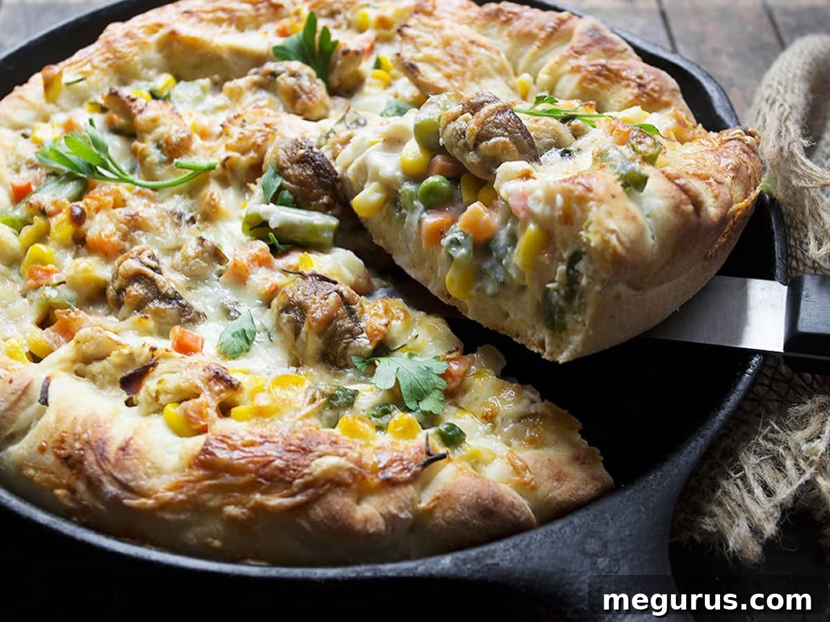 Delicious deep-dish turkey pot pie pizza in a cast iron skillet, perfect for using Thanksgiving leftovers.