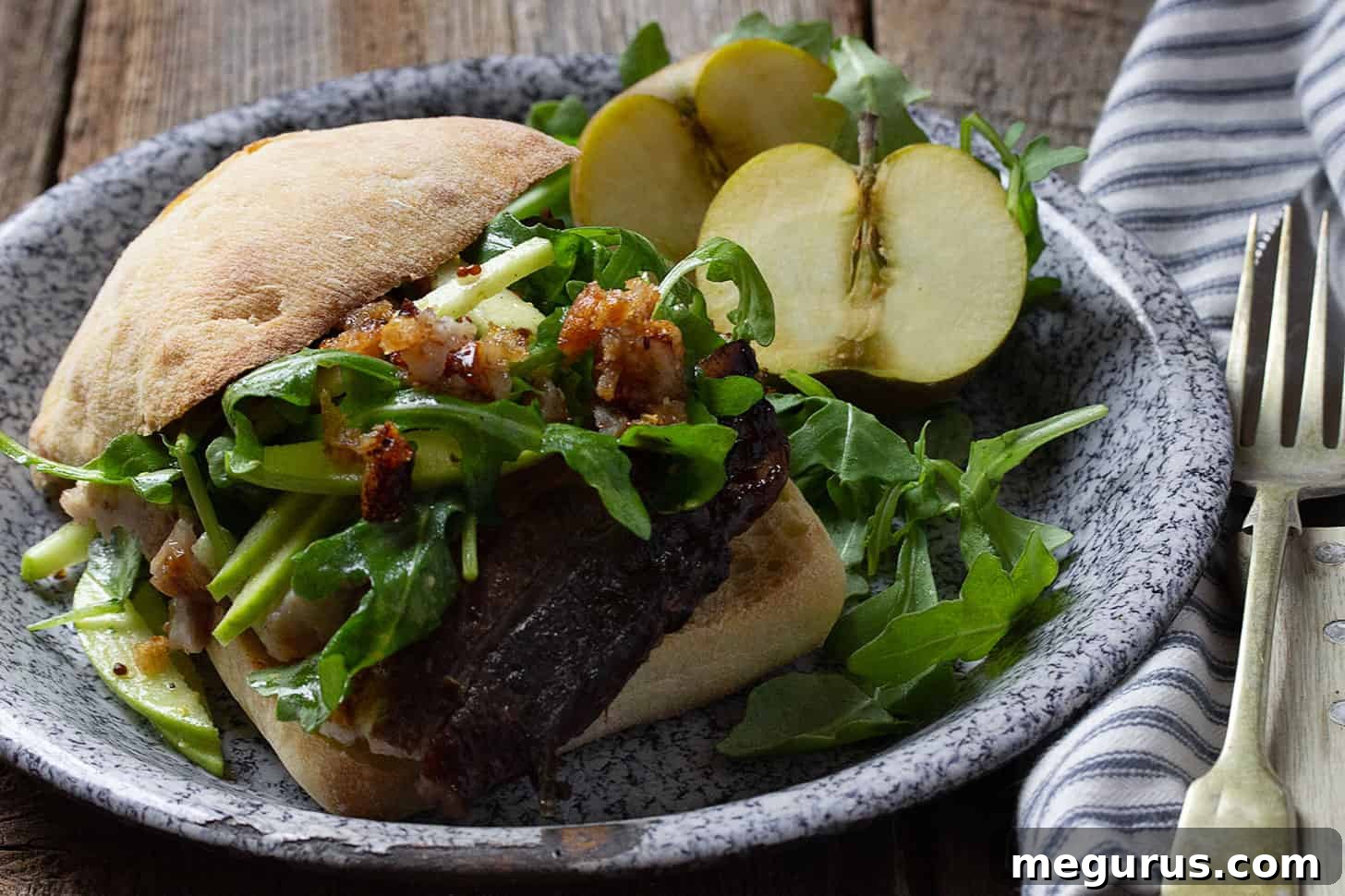 Delicious apple braised pork belly sandwich on a rustic plate, ready to be enjoyed.