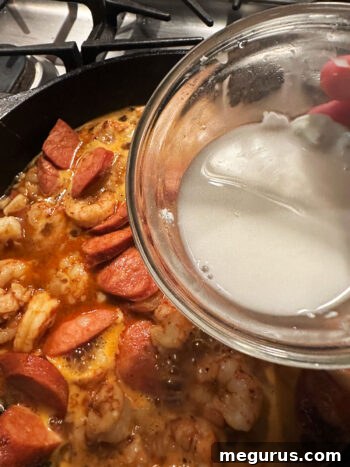 Thickening sauce with cornstarch slurry.