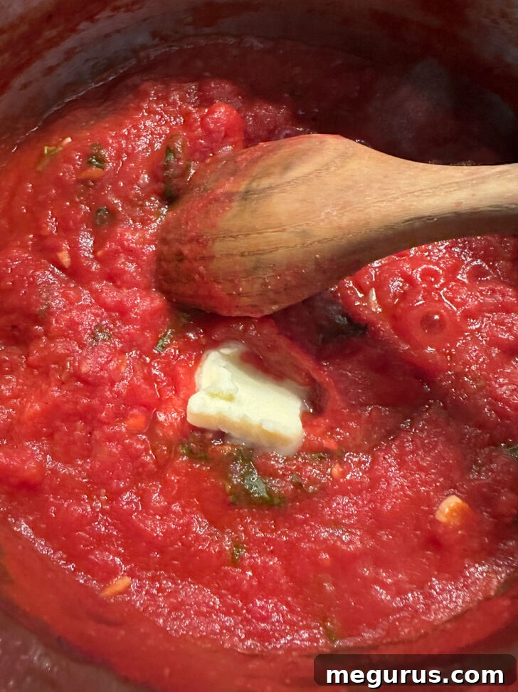 adding butter to finish tomato sauce