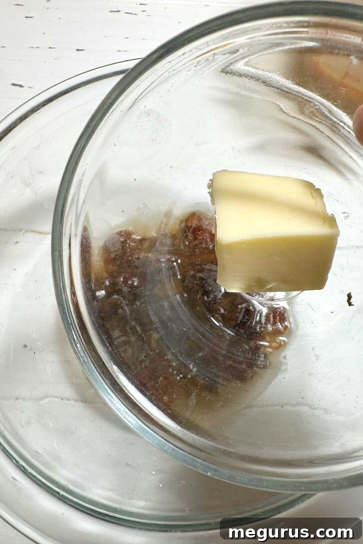 Adding butter to soaking dates in a bowl, preparing the cake base