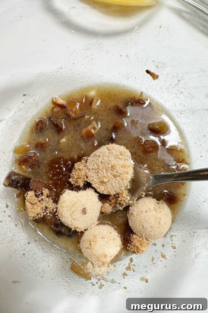Adding brown sugar to the warm, softened date and butter mixture