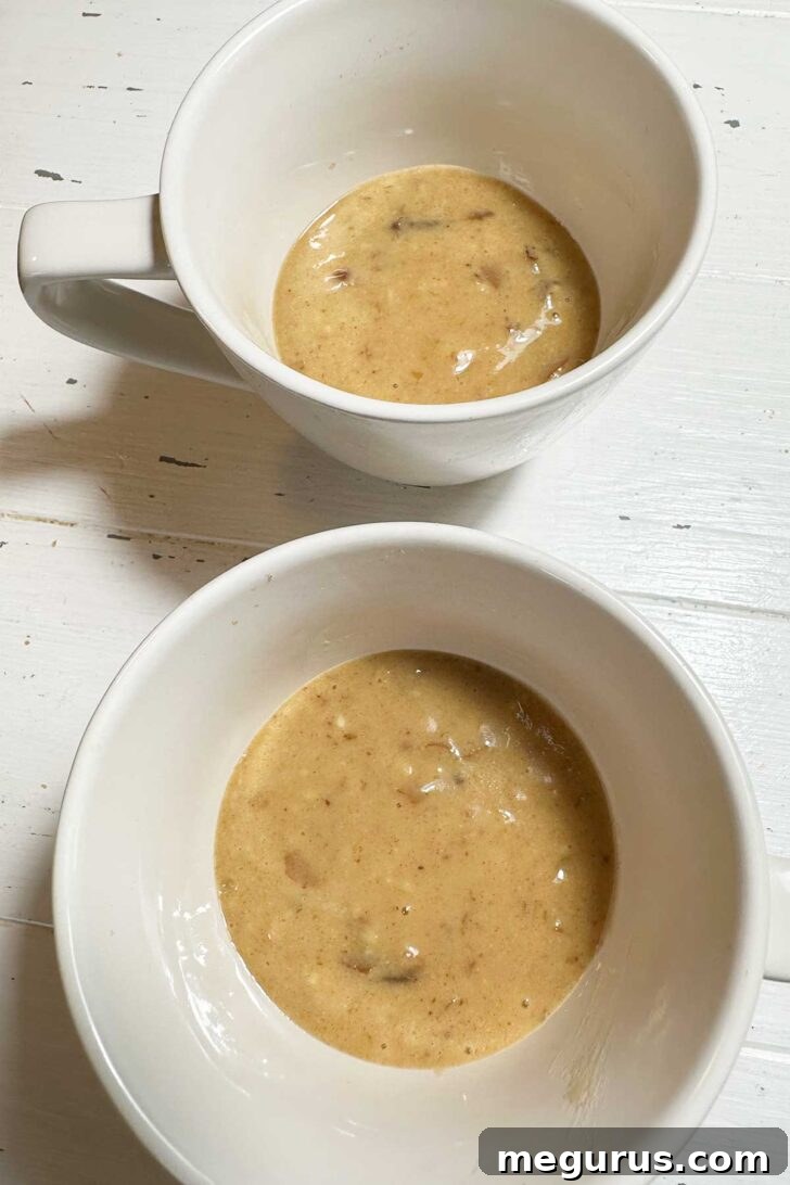 Dividing the sticky toffee pudding batter into two microwave-safe mugs