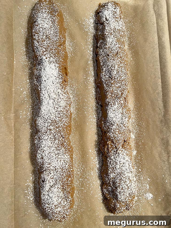 Gingerbread biscotti dough logs dusted with icing sugar before the first bake.